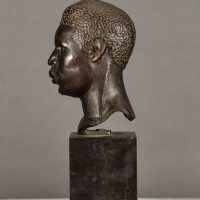Alt text: Bronze bust of the head of a boxer