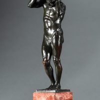 Alt text: Bronze sculpture of a nude figure holding a rock above his head