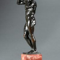 Alt text: Bronze sculpture of a nude figure holding a rock above his head