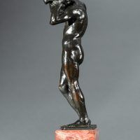 Alt text: Bronze sculpture of a nude figure holding a rock above his head