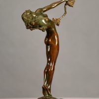 Alt text: Bronze sculpture of a nude woman with back arched, holding a vine in her extended left hand draping over her body