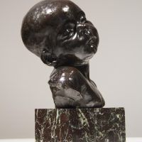 Alt text: Bronze bust of an infant head