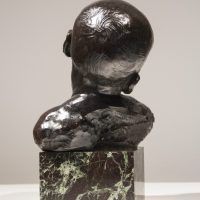 Alt text: Bronze bust of an infant head