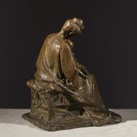 Alt text: Bronze sculpture of a mother tending to the baby seated on her lap