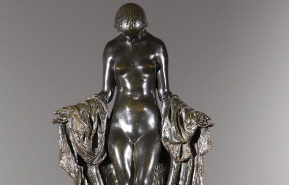 Alt text: Bronze sculpture of a nude woman holding a piece of fabric behind her