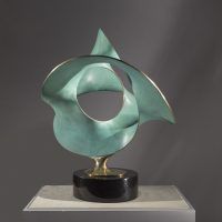 Alt text: Polished bronze sculpture of three warped circles
