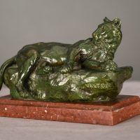 Alt text: Bronze sculpture of a reclining lioness