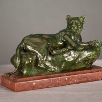 Alt text: Bronze sculpture of a reclining lioness