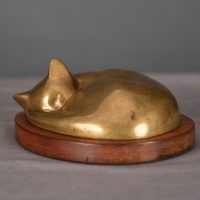 Bronze sculpture of a sleeping cat curled up