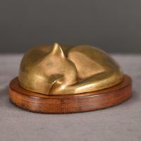 Bronze sculpture of a sleeping cat curled up