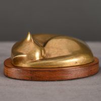 Bronze sculpture of a sleeping cat curled up