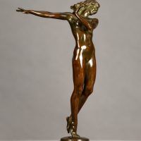 Alt text: Bronze sculpture of a nude woman posing with her right arm extended to the side