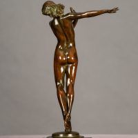 Alt text: Bronze sculpture of a nude woman posing with her right arm extended to the side