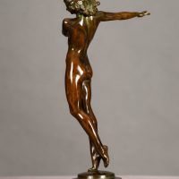 Alt text: Bronze sculpture of a nude woman posing with her right arm extended to the side