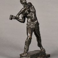 Alt text: Bronze sculpture of a muscular shirtless man swinging a hammer