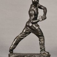 Alt text: Bronze sculpture of a muscular shirtless man swinging a hammer