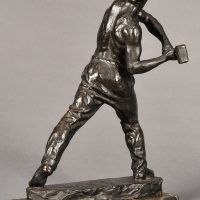 Alt text: Bronze sculpture of a muscular shirtless man swinging a hammer