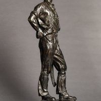 Alt text: Bronze sculpture of a telephone linesman in work gear