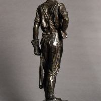 Alt text: Bronze sculpture of a telephone linesman in work gear