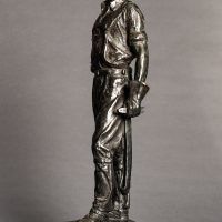 Alt text: Bronze sculpture of a telephone linesman in work gear