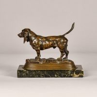 Alt text: Bronze sculpture of a Basset Hound with tale up, side view