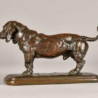 Alt text: Bronze sculpture of a standing Basset Hound with tale extended