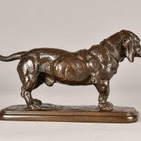 Alt text: Bronze sculpture of a standing Basset Hound with tale extended