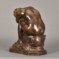 Alt text: Bronze sculpture of a seated nude woman bent over crying into her arms