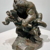 Alt text: Bronze sculpture of a bear catching an owl in his maw