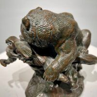 Alt text: Bronze sculpture of a bear catching an owl in his maw