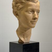 Alt text: Terracotta bust of a young woman's face