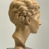 Alt text: Terracotta bust of a young woman's face
