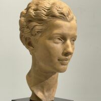 Alt text: Terracotta bust of a young woman's face