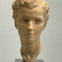 Alt text: Terracotta bust of a young woman's face