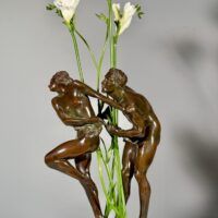 Alt text: Bronze sculpture of two figures with flowers in the center