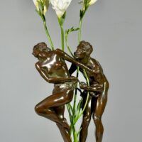 Alt text: Bronze sculpture of two figures with flowers in the center