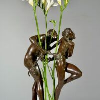 Alt text: Bronze sculpture of two figures with flowers in the center