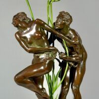 Alt text: Bronze sculpture of two figures with flowers in the center