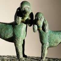 Alt text: Bronze sculpture of two poodles