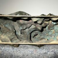 Alt text: Underside of a bronze sculpture of a pioneer woman