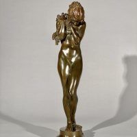 Alt text: Bronze sculpture of a nude woman standing and cradling grapes over her shoulder and into her chest, frontal view