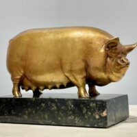 Alt text: Bronze sculpture of a pig