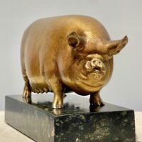 Alt text: Bronze sculpture of a pig