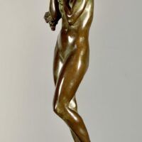 Alt text: Bronze sculpture of a woman holding grapes