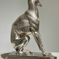 Alt text: Silvered bronze sculpture of a seated dog