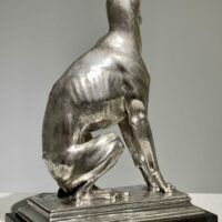 Alt text: Silvered bronze sculpture of a seated dog