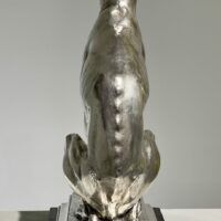 Alt text: Silvered bronze sculpture of a seated dog