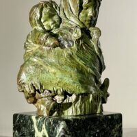 Alt text: Bronze sculpture of woman with child on her back