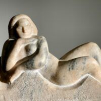 Alt text: Marble carving of a reclining nude woman