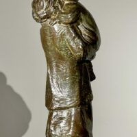 Alt text: Bronze sculpture of a young woman carrying her baby in 1910s clothing